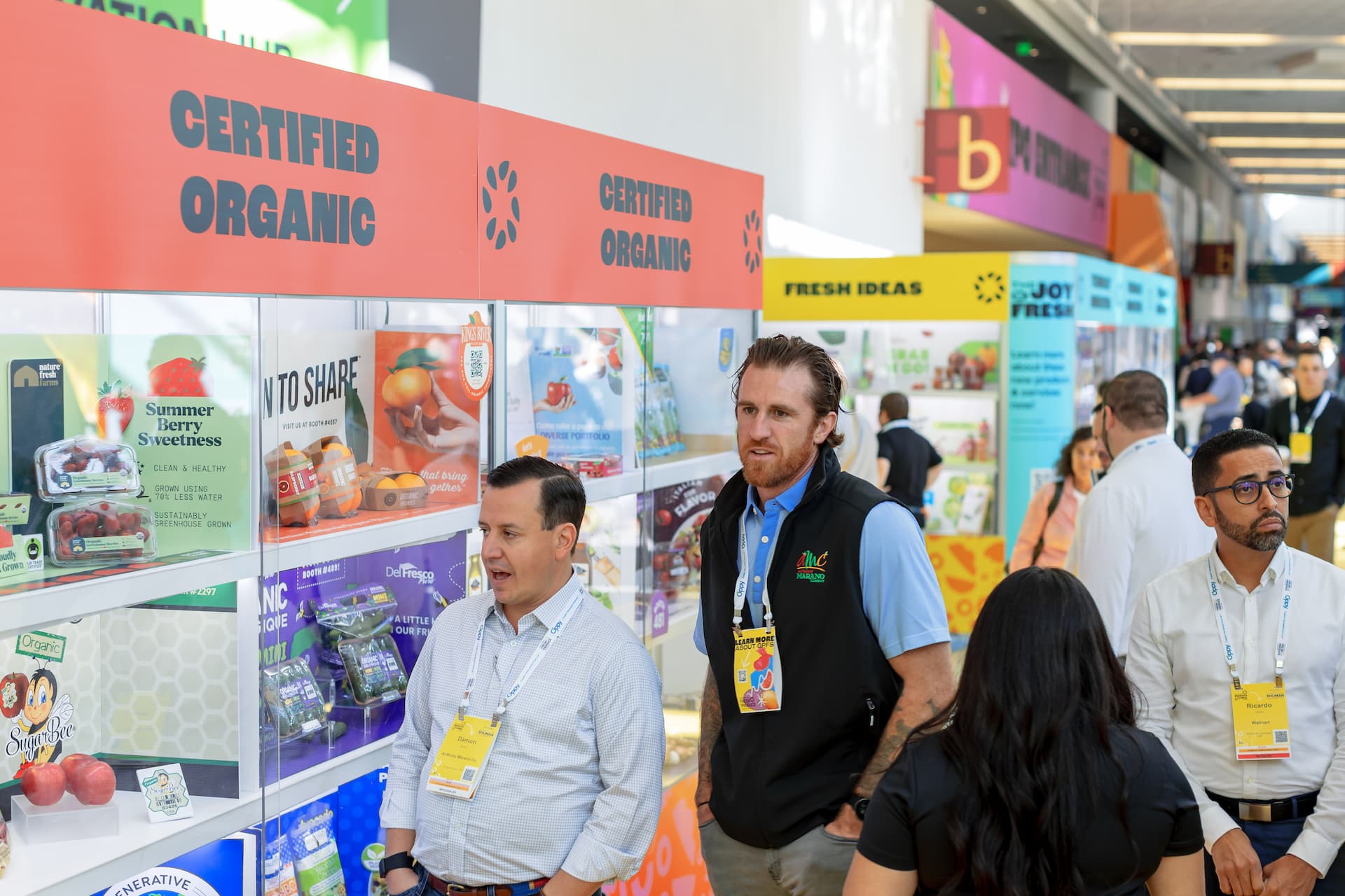 People in a spacious indoor area, attentively observing various products related to Certified Organics at Fresh Ideas 2023.