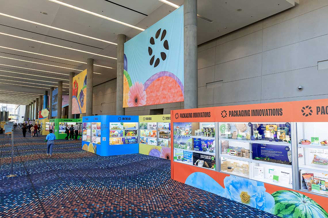 Exhibition hall with colorful display booths and hanging banners.