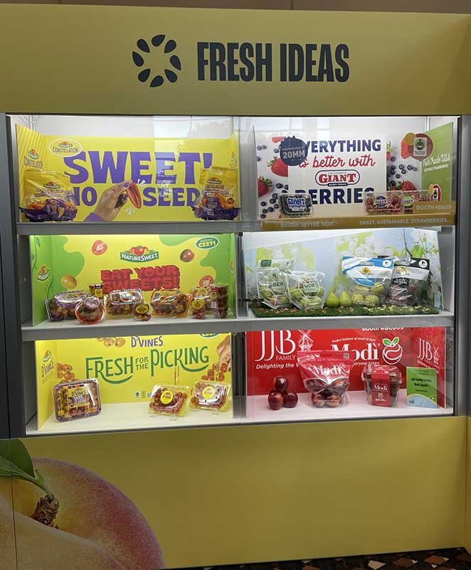 Display shelf with various packaged fruits including grapes, tomatoes, and apples, under the banner "FRESH IDEAS".