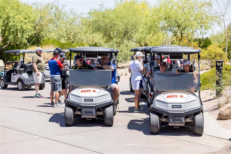 Attendees at 2024 Retail Conference prepare for golf in their golf carts.